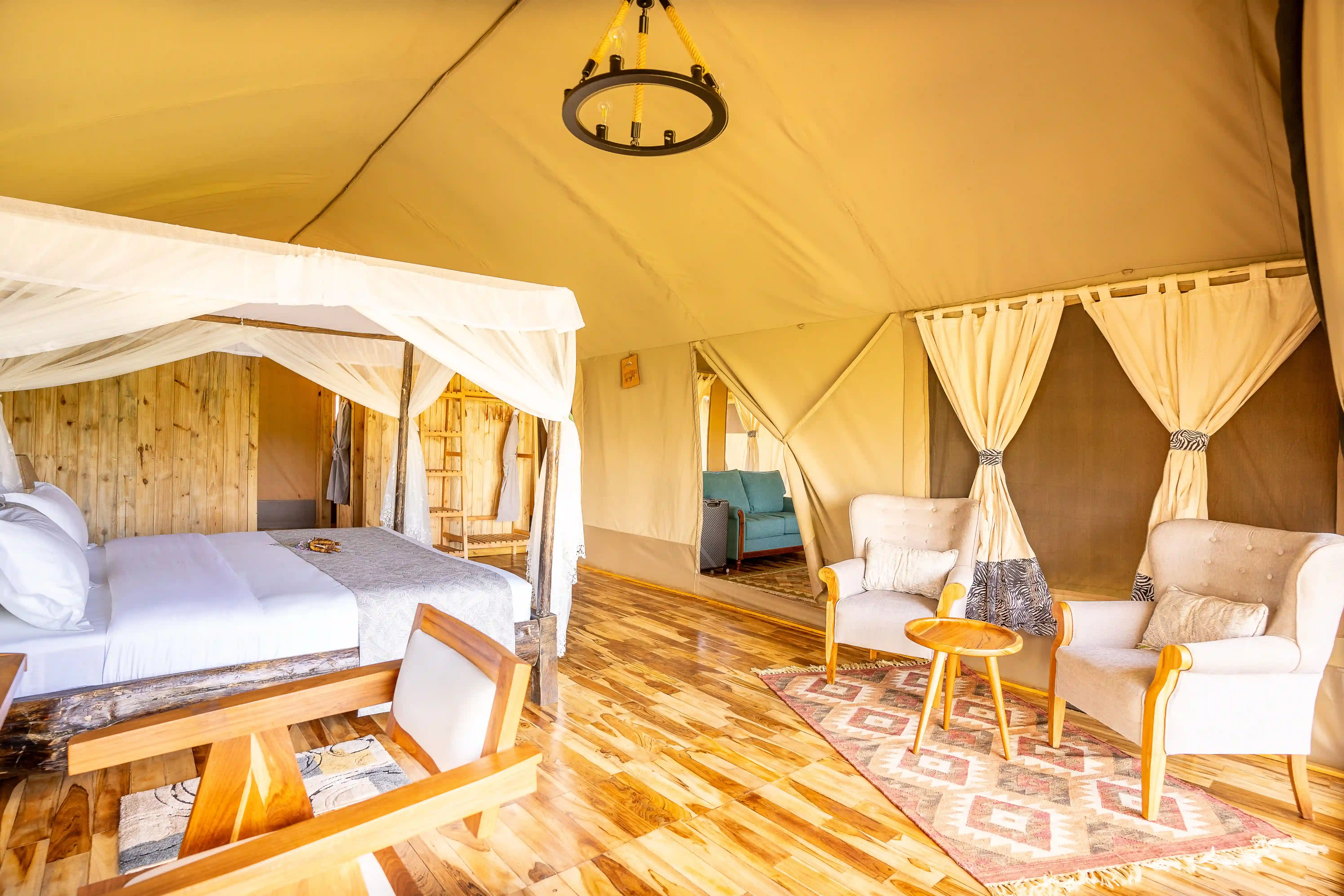 Elegant tent interior with four-poster bed and chandelier