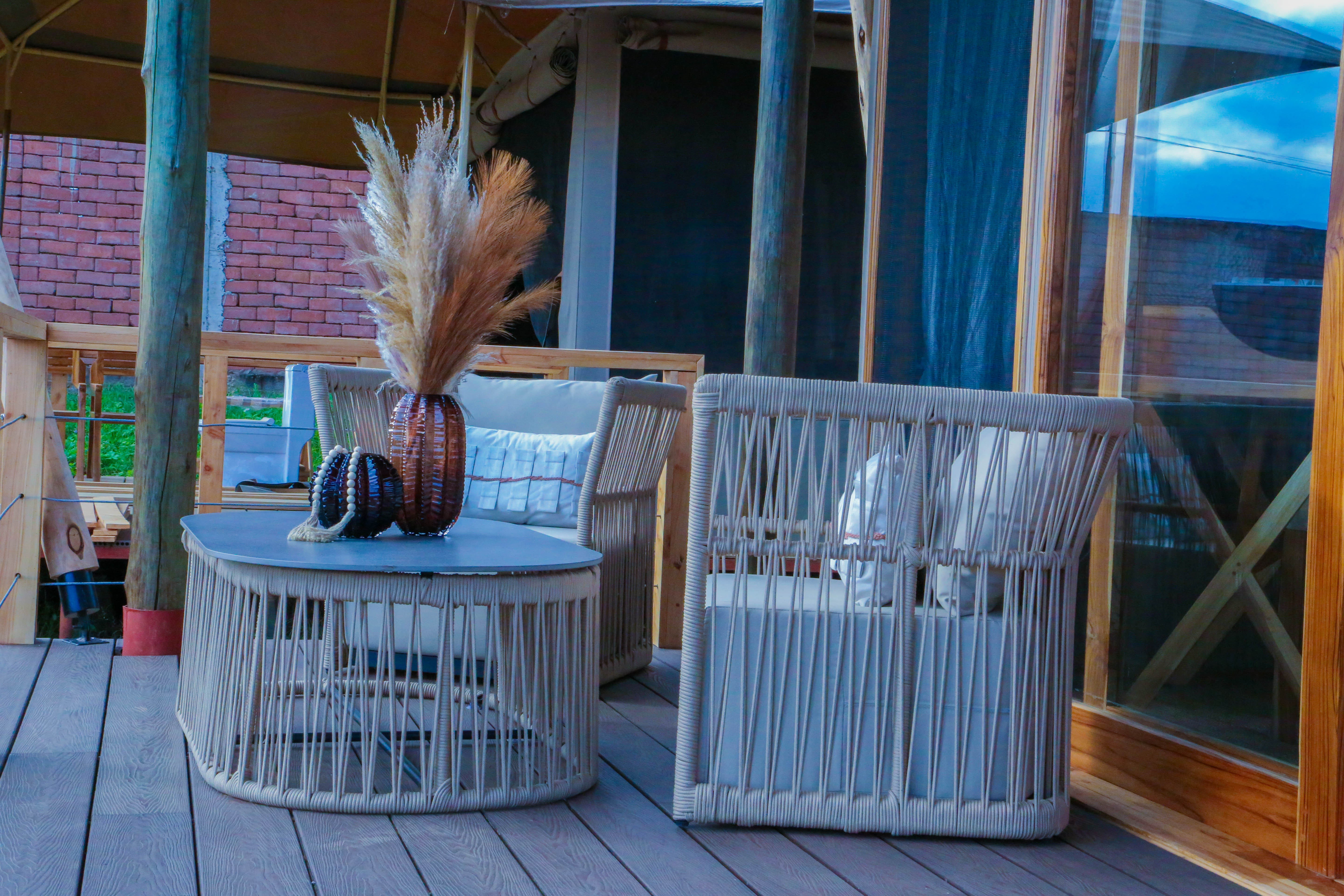 Outdoor seating area with woven rope furniture and pampas grass decoration