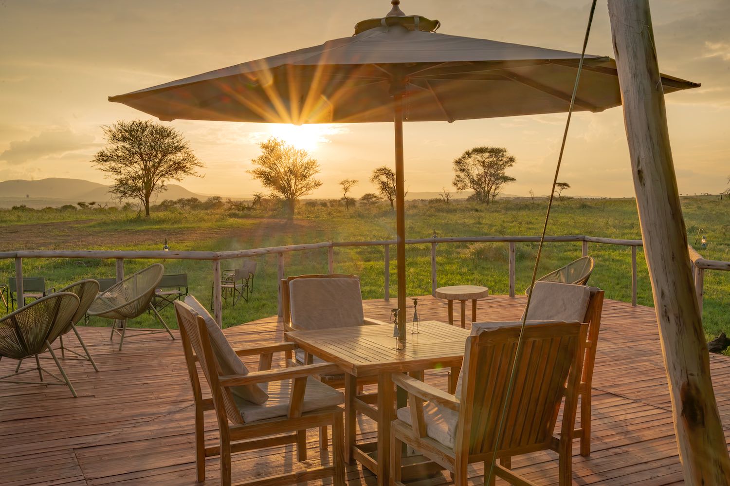 Wooden deck lounge area with sunset views over savanna