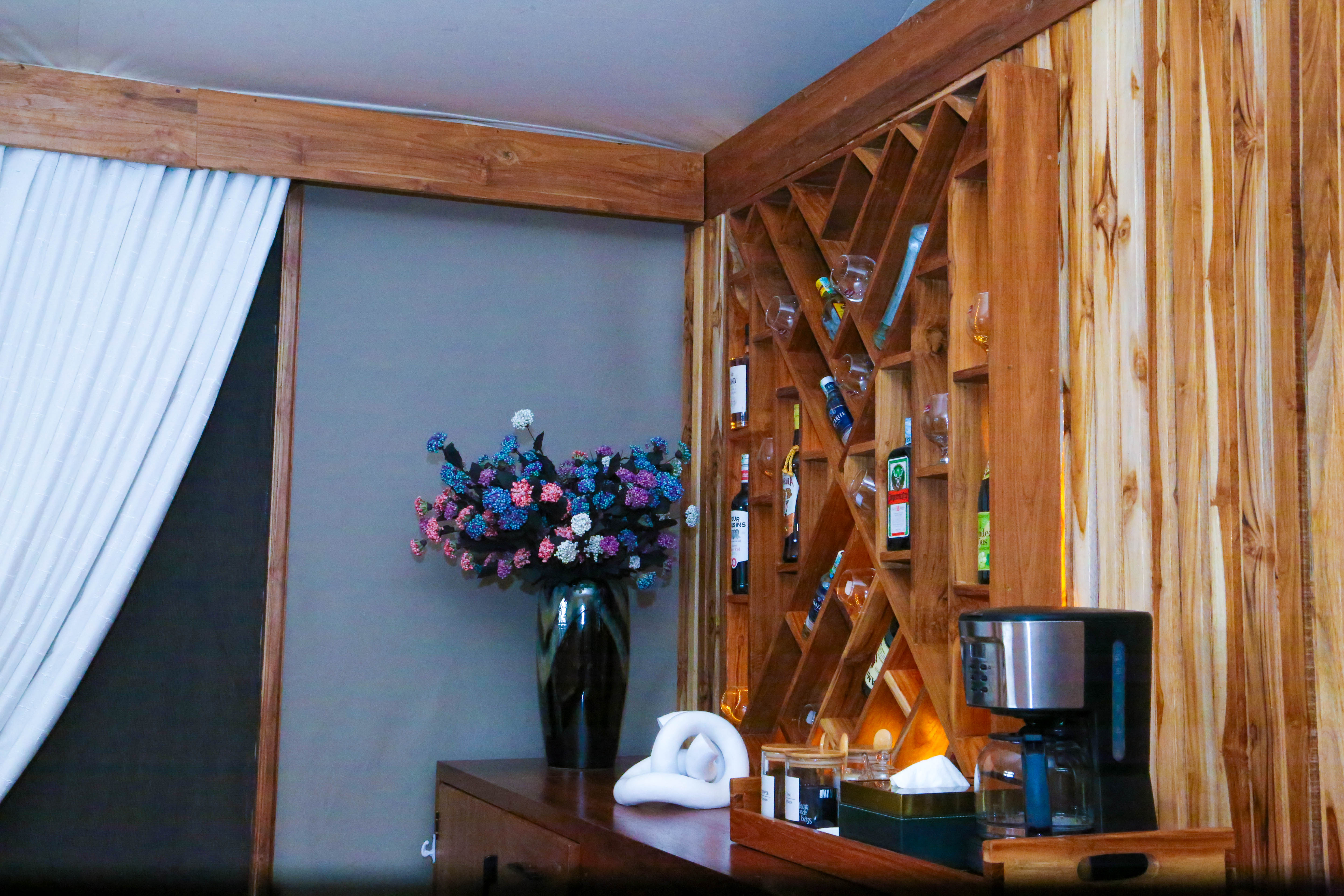 Rustic kitchen area with wooden wine rack storage and decorative flowers