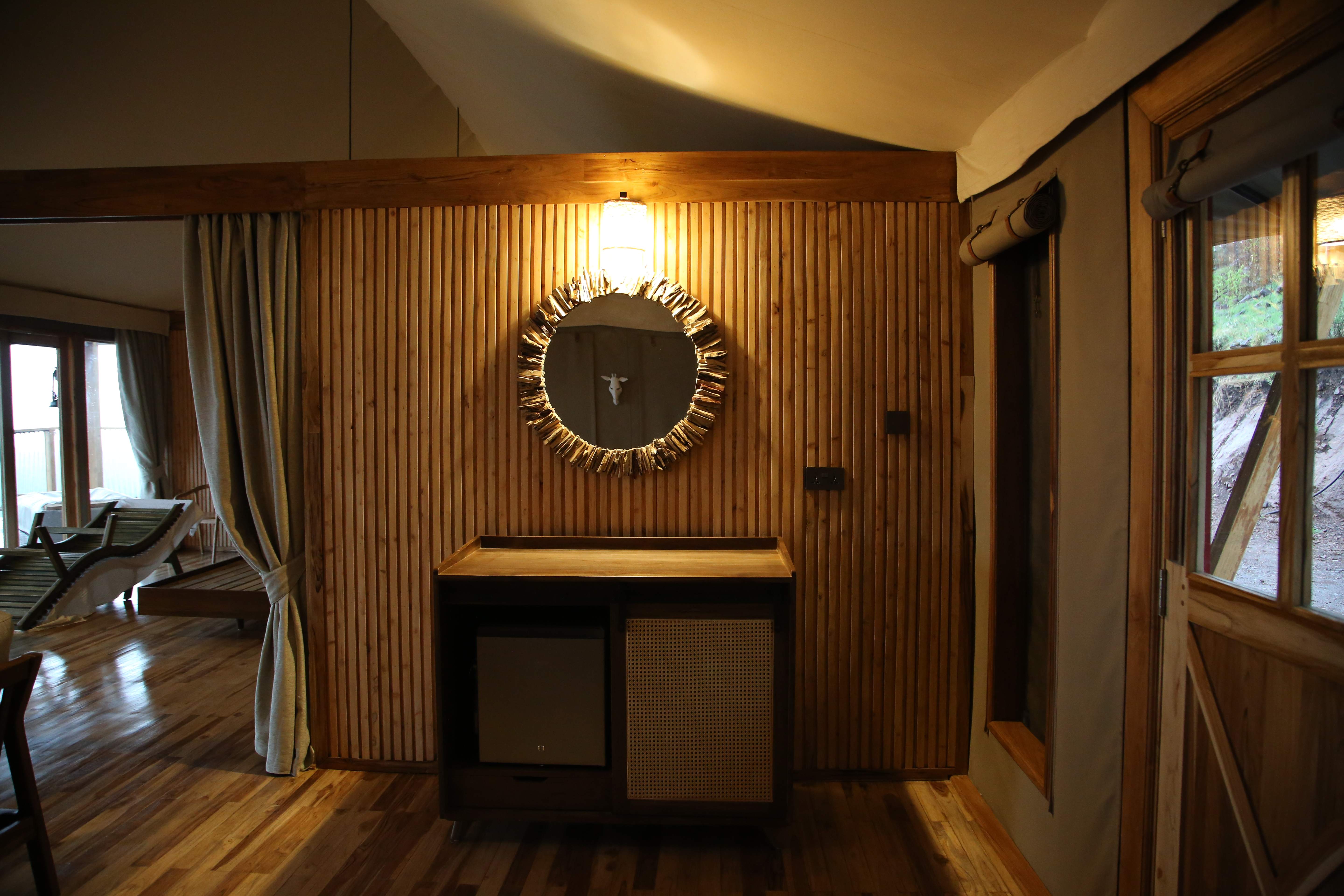 Living room with wooden slat wall, circular mirror, and modern fireplace