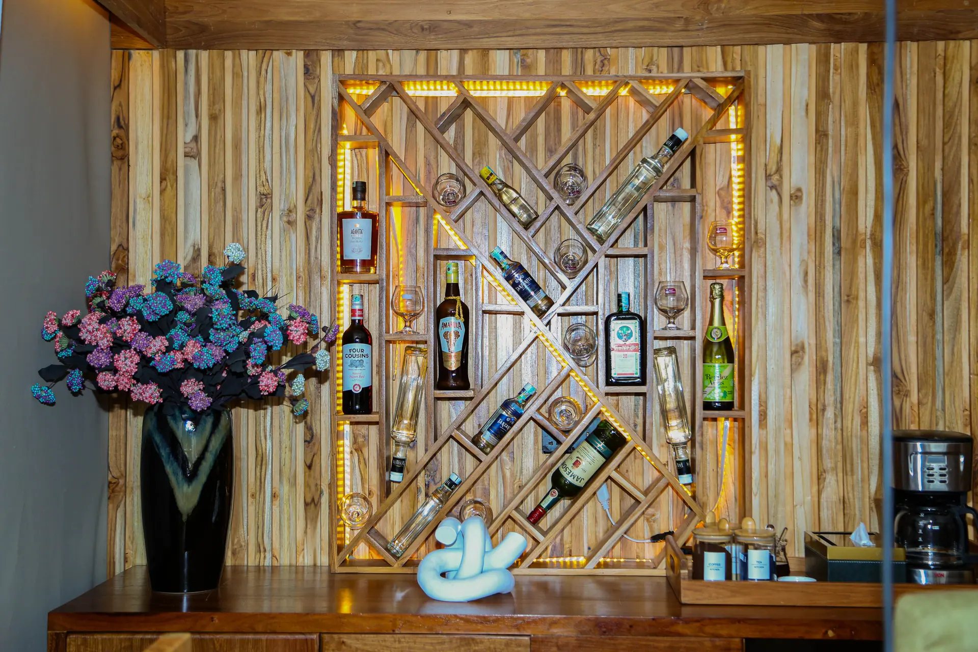 Illuminated wooden wine rack with geometric diamond pattern and LED lighting