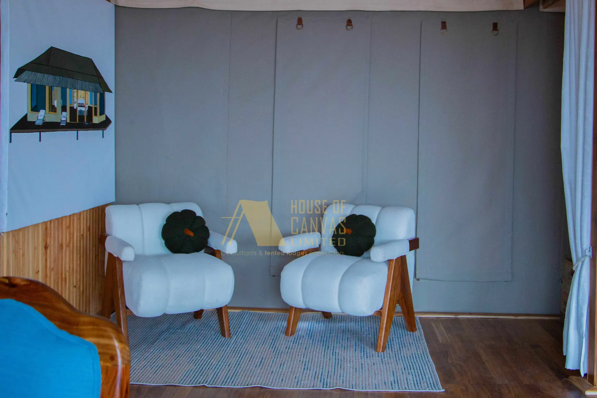 Modern interior seating area with white armchairs and House of Canvas branding
