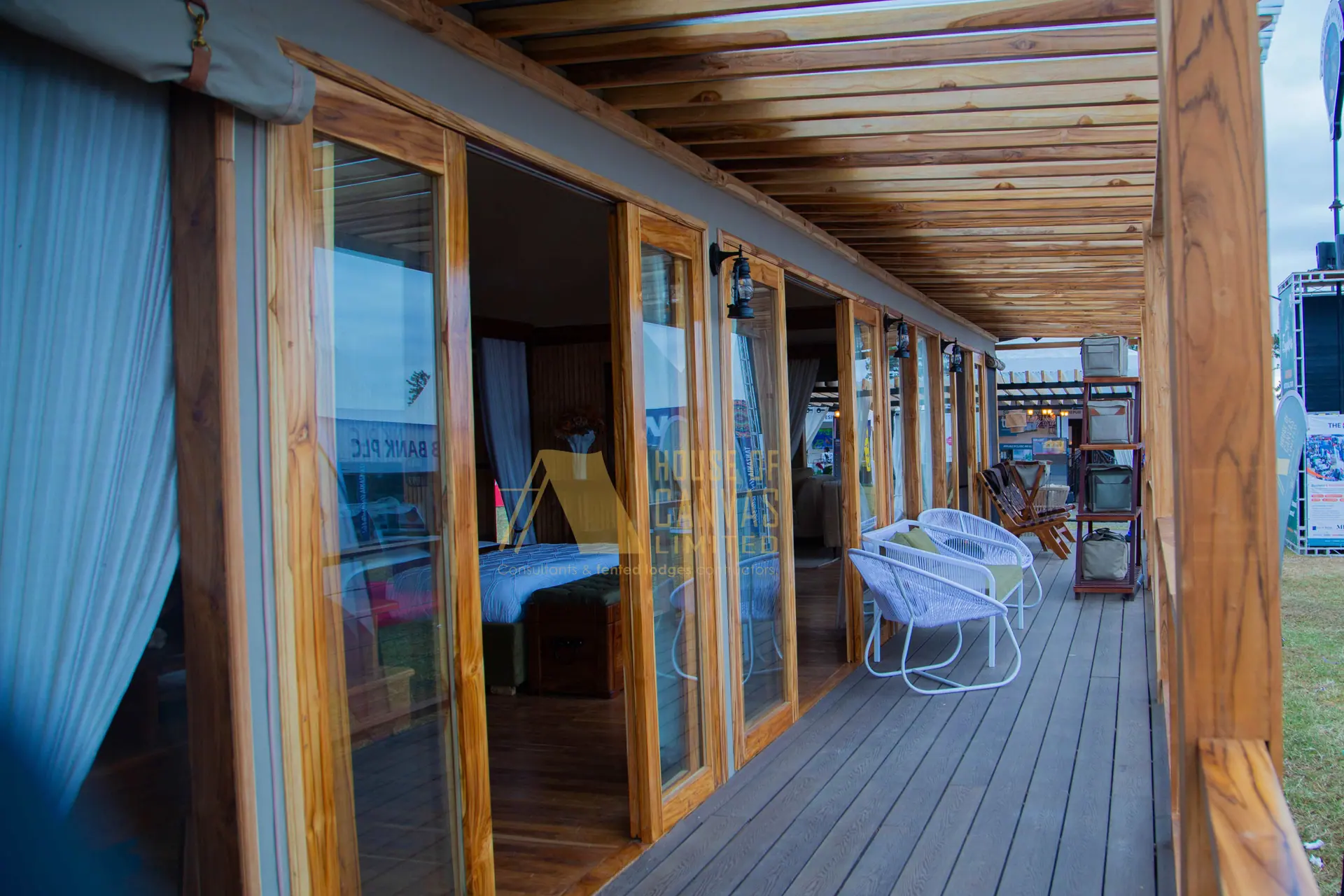 Covered wooden deck veranda with glass windows and outdoor furniture