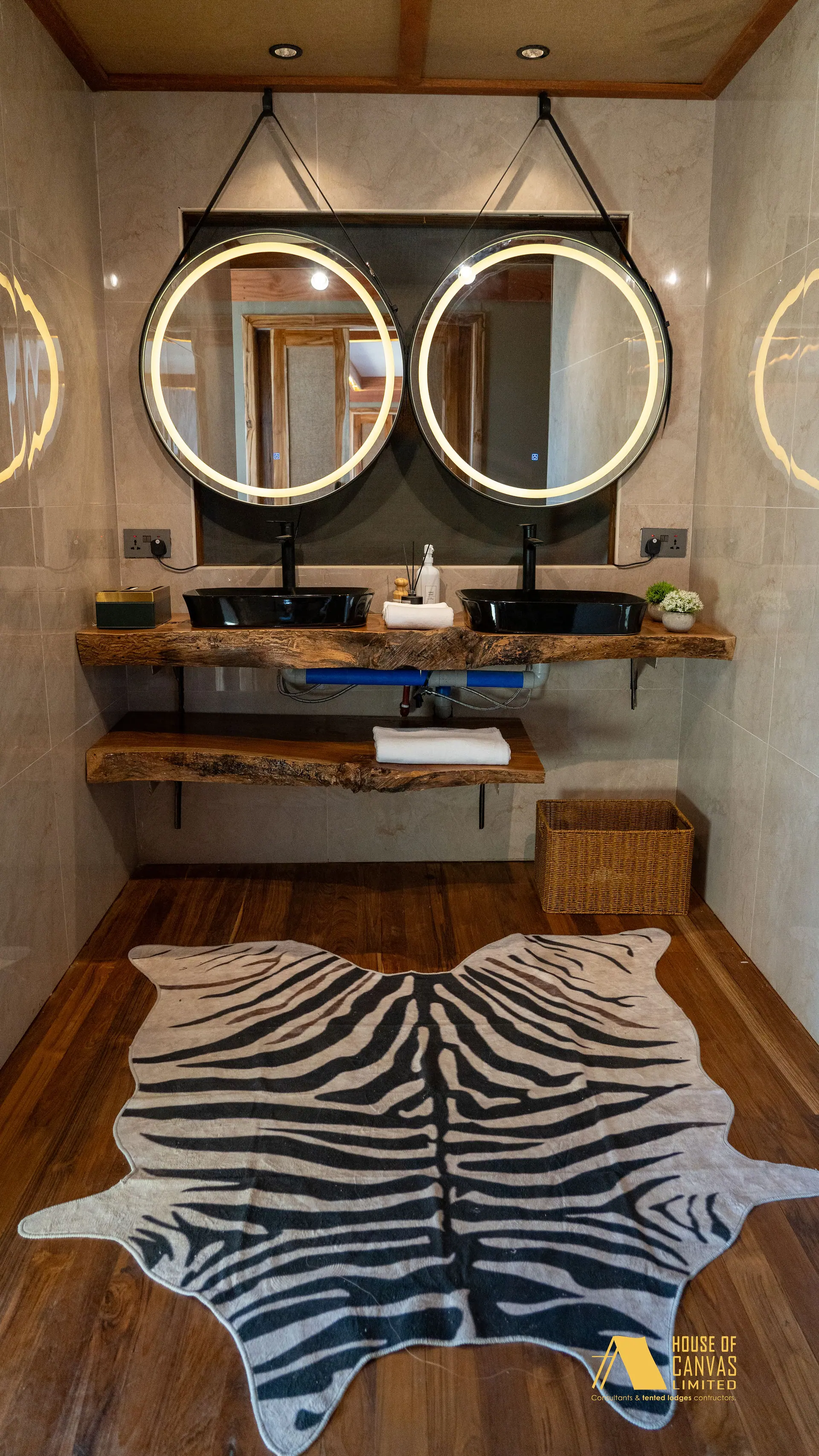 Full view of the Kili Fair 2026 bathroom with zebra hide rug and twin stone basins