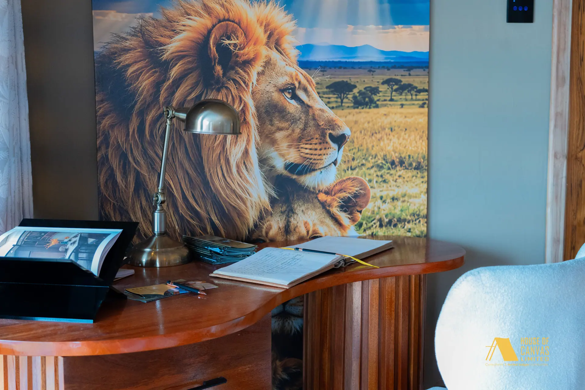 Curved timber writing desk with brass lamp and lion artwork at Kili Fair 2026